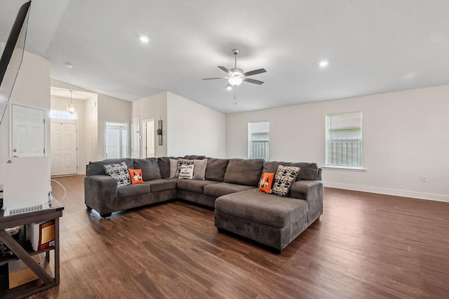 living room with dark wood-type flooring, vaulted ceiling, and ceiling fan