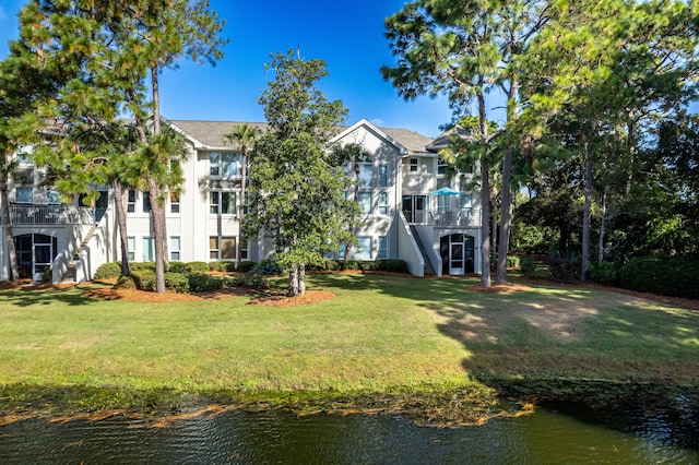 exterior space with a water view and a lawn