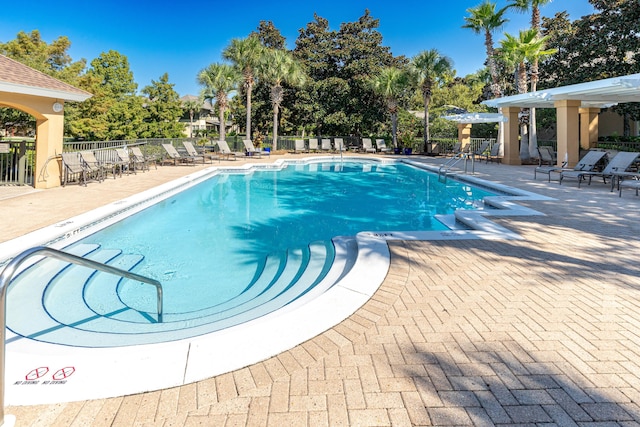 community pool featuring a patio and fence