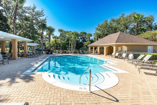 community pool with fence and a patio area