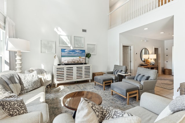 living area with visible vents and a towering ceiling