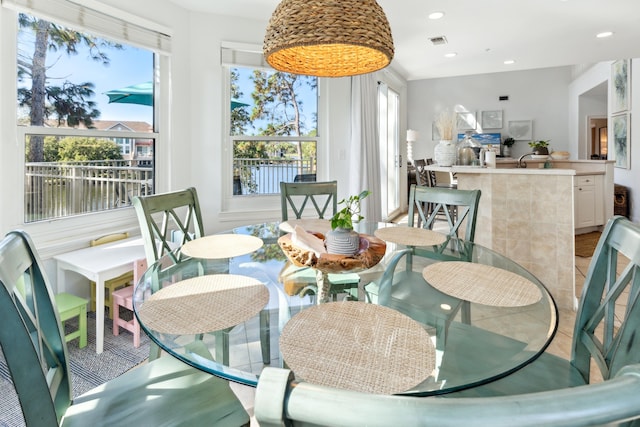 dining room featuring a water view and a healthy amount of sunlight