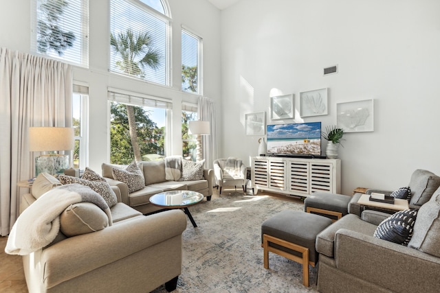 living room featuring visible vents and a towering ceiling