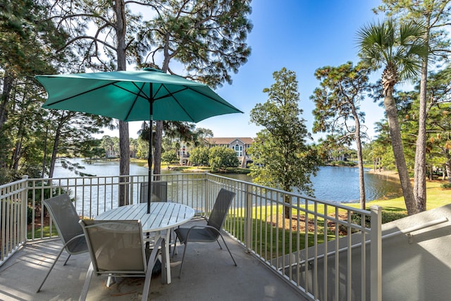 balcony featuring a water view and outdoor dining space