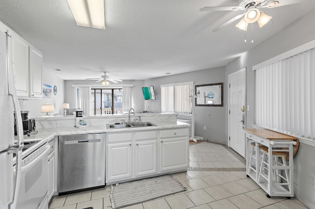 kitchen with sink, dishwasher, white electric stove, kitchen peninsula, and white cabinets