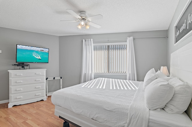 bedroom featuring a textured ceiling, light wood-type flooring, and ceiling fan