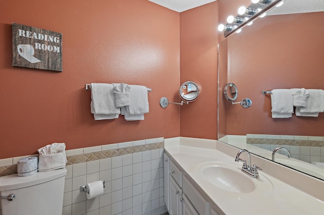 285 Payne St Unit 20B, Miramar Beach, FL 32550 - bathroom featuring toilet, vanity, tile walls, and a wainscoted wall