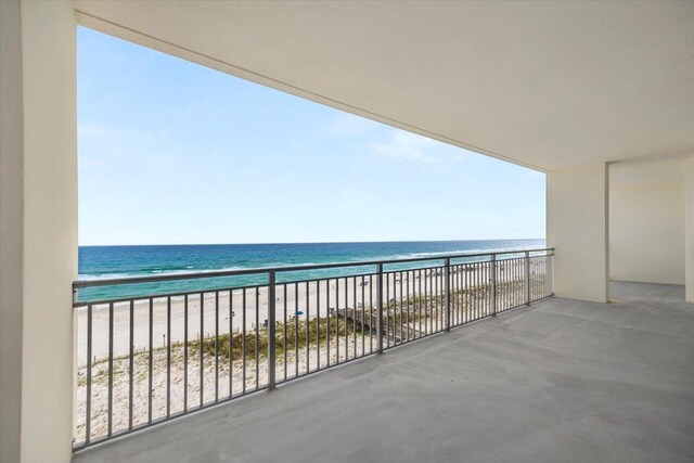 balcony featuring a view of the beach and a water view