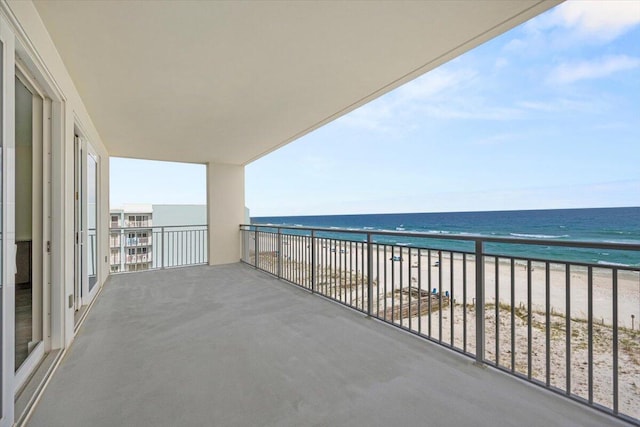 balcony featuring a water view and a view of the beach