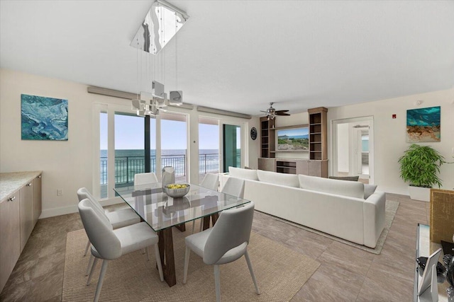 dining space featuring ceiling fan and baseboards