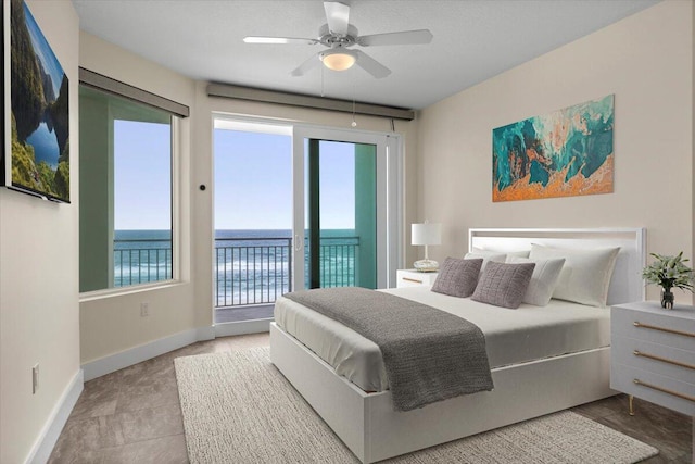 bedroom with access to outside, a water view, ceiling fan, and baseboards