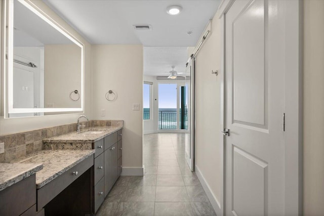 bathroom with visible vents, ceiling fan, vanity, tile patterned flooring, and baseboards