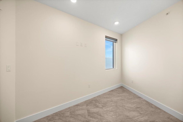 unfurnished room featuring recessed lighting, light carpet, and baseboards