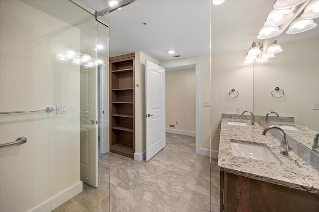 bathroom with a sink, baseboards, and double vanity