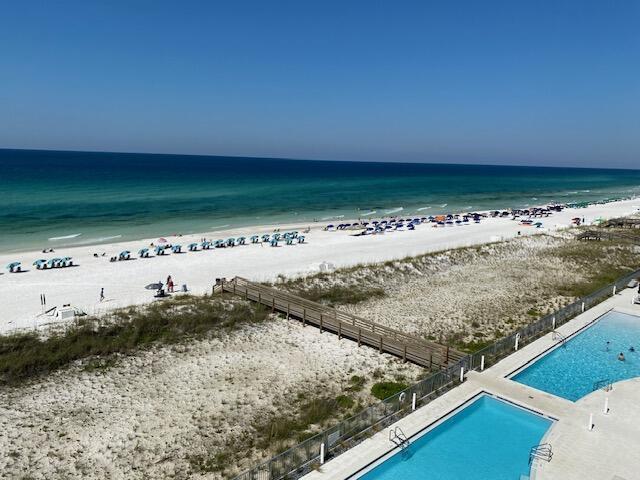 view of water feature with fence and a beach view