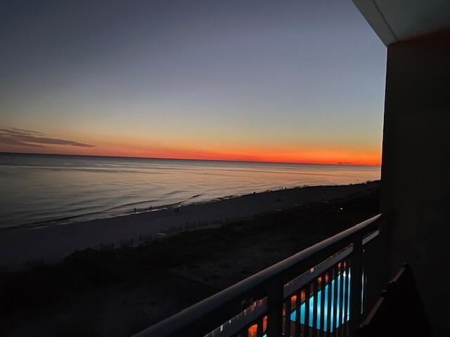 balcony featuring a water view and a beach view