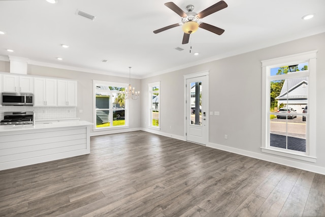 unfurnished living room featuring crown molding, ceiling fan with notable chandelier, and dark hardwood / wood-style flooring