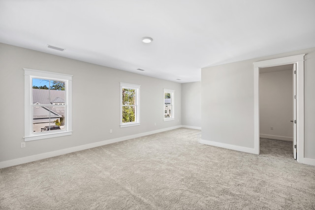 empty room with a healthy amount of sunlight and light colored carpet