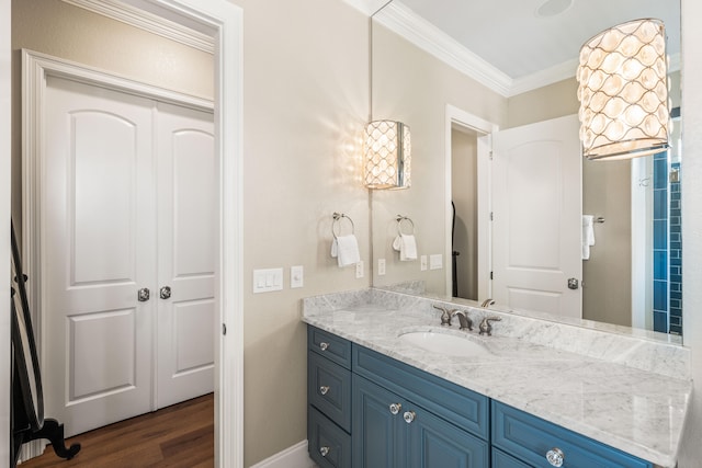 bathroom with vanity, crown molding, and hardwood / wood-style flooring