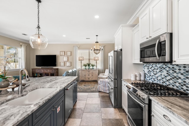 18 Spyglass Dr, Miramar Beach, FL 32550 - kitchen featuring stainless steel appliances, white cabinets, backsplash, a chandelier, and crown molding