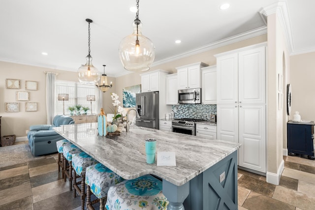 18 Spyglass Dr, Miramar Beach, FL 32550 - kitchen with stainless steel appliances, a breakfast bar, a large island, white cabinets, and ornamental molding