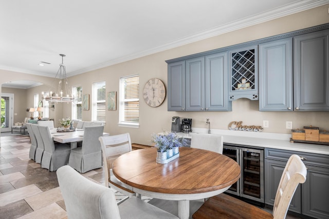 18 Spyglass Dr, Miramar Beach, FL 32550 - dining space with beverage cooler, arched walkways, ornamental molding, a chandelier, and a dry bar