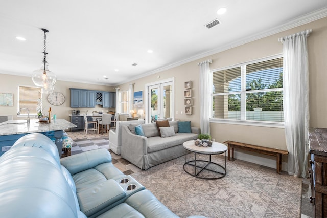 living room with sink, crown molding, and a wealth of natural light