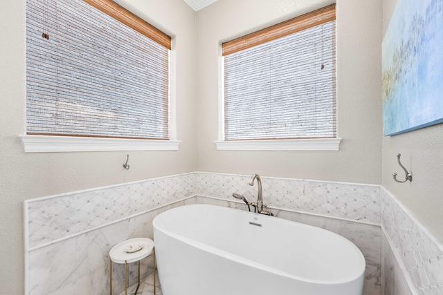 18 Spyglass Dr, Miramar Beach, FL 32550 - bathroom featuring a freestanding tub, wainscoting, and tile walls