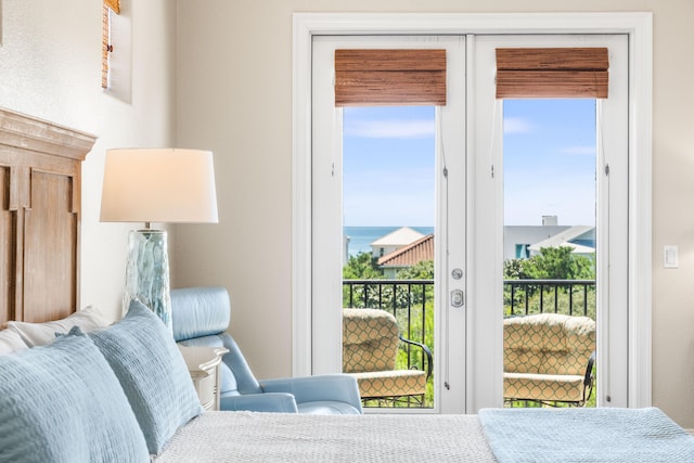 bedroom with a water view and access to outside