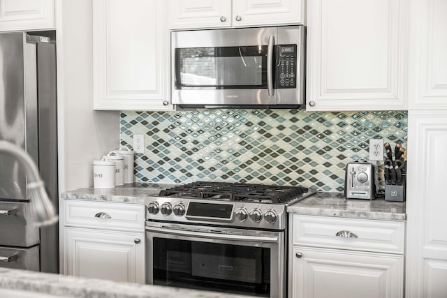 kitchen featuring decorative backsplash, white cabinets, and stainless steel appliances