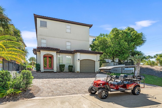 18 Spyglass Dr, Miramar Beach, FL 32550 - mediterranean / spanish home featuring a tile roof, decorative driveway, stucco siding, an attached garage, and french doors