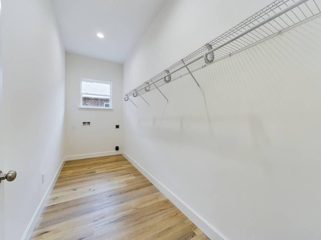 laundry room featuring hookup for a washing machine, hookup for an electric dryer, and light hardwood / wood-style floors