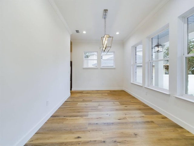 unfurnished dining area with ornamental molding and light hardwood / wood-style flooring