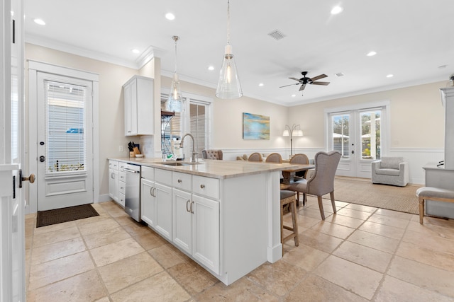 kitchen featuring crown molding, sink, a kitchen breakfast bar, white cabinetry, and light stone counters