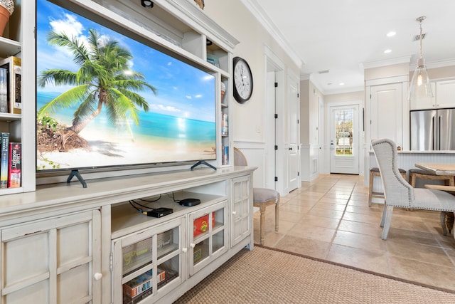 interior space featuring crown molding, decorative light fixtures, and stainless steel refrigerator