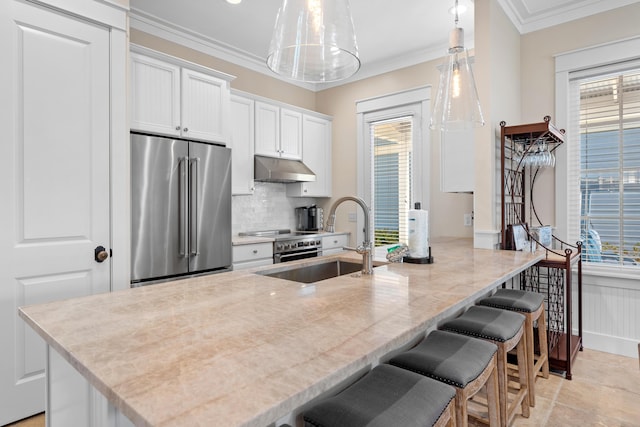 2448 Bungalo Ln, Miramar Beach, FL 32550 - kitchen featuring appliances with stainless steel finishes, a sink, healthy amount of natural light, white cabinetry, and ornamental molding