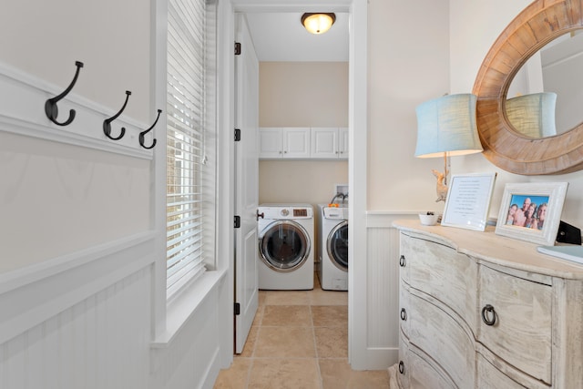 washroom with washer and clothes dryer, light tile patterned flooring, a healthy amount of sunlight, and cabinets