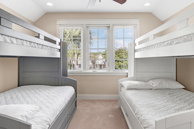 carpeted bedroom featuring vaulted ceiling, multiple windows, and ceiling fan