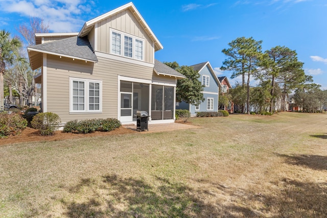 rear view of property with a yard and a sunroom