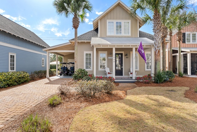 view of front facade featuring covered porch, a front yard, and a carport