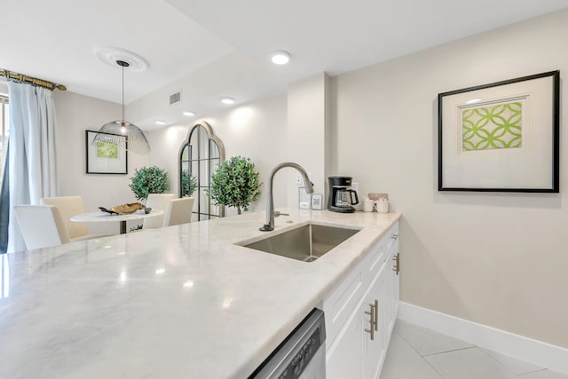 kitchen with light stone countertops, sink, hanging light fixtures, white cabinets, and light tile patterned floors