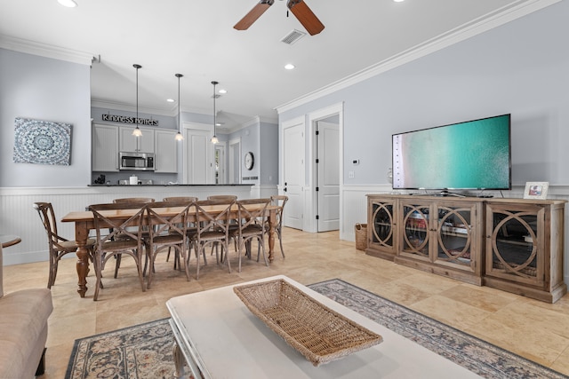 dining area with crown molding and ceiling fan