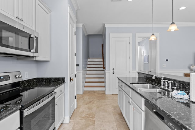 kitchen with stainless steel appliances, sink, dark stone counters, and white cabinets