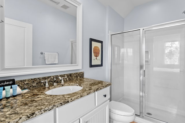 bathroom with vanity, lofted ceiling, toilet, and an enclosed shower