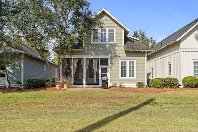 2452 Bungalo Ln, Miramar Beach, FL 32550 - rear view of house featuring a sunroom, a lawn, and a shingled roof