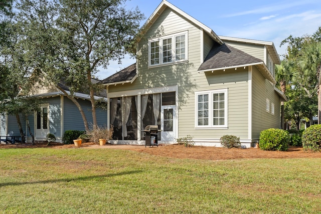 rear view of property with a yard and a sunroom