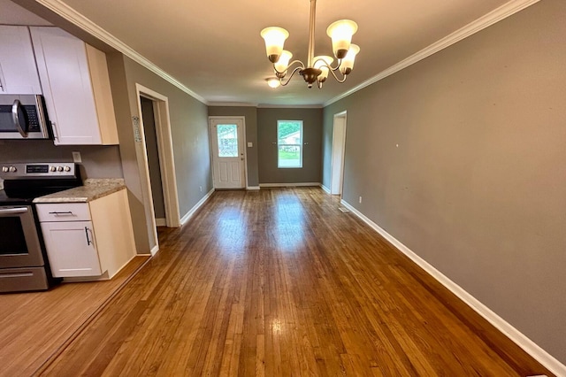 297 Anderson St, Crestview, FL 32536 - unfurnished dining area with wood finished floors, crown molding, baseboards, and a chandelier
