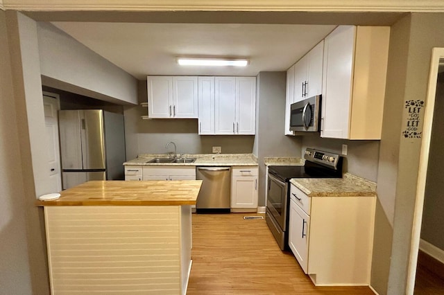 297 Anderson St, Crestview, FL 32536 - kitchen with appliances with stainless steel finishes, a sink, butcher block counters, light wood-type flooring, and white cabinets