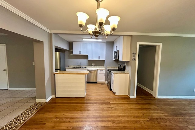 297 Anderson St, Crestview, FL 32536 - kitchen featuring stainless steel appliances, ornamental molding, a sink, a chandelier, and wood finished floors