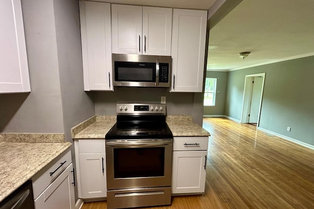 297 Anderson St, Crestview, FL 32536 - kitchen featuring stainless steel appliances, white cabinets, light wood-style flooring, crown molding, and baseboards
